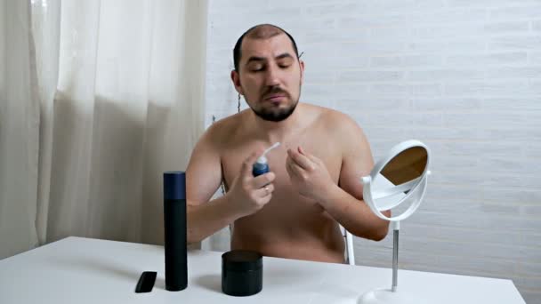 在镜子前秃顶的男人会照顾好自己的头发，在头发脱落时使用一种头发生长的方法. — 图库视频影像