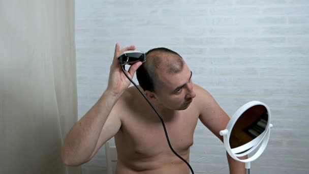 Ο τύπος ξυρίζει το κεφάλι του με ξυράφι. Αποτρίχωση στο σπίτι — Αρχείο Βίντεο