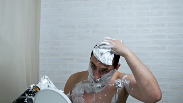 Un hombre extraño se afeita el pelo en la cabeza usando espuma de afeitar y patines de hockey, quitándose el pelo con una cuchilla de sus patines. Extracción inusual del cabello de un hombre de verdad — Vídeos de Stock