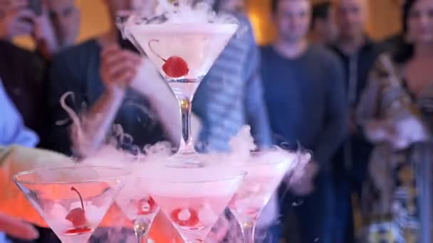 Cocktail fumé à une fête. Un tas de verres d'alcool et de cerise, d'où vient la fumée. Cocktail créatif dans une boîte de nuit. Pyramide de champagne à la fête. Mouvement lent — Video