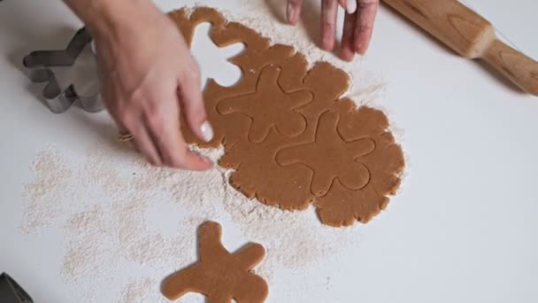 Ama de casa hace galletas de Navidad. Mujer cortar la forma de pan de jengibre en forma de un árbol de Navidad de masa cruda — Vídeos de Stock