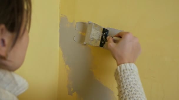 Het meisje spuugt de gele muur in de kamer voor het schilderen. Vervreemding. De gewrichten vastmaken. Jonge vrouw kleedt de gewrichten in de muur voor het schilderen — Stockvideo