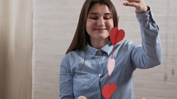 Young attractive girl made preparing heart decorations in an apartment on Valentines Day — 비디오