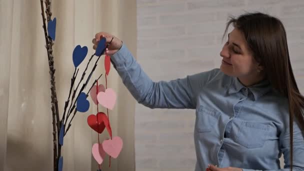 Card for valentines day with text happy valentines day.Valentine.Young attractive girl made decorations in the form of a heart tree for Valentines Day — Stock Video