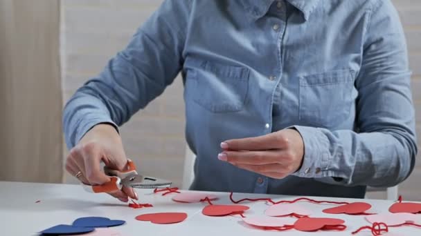 Joven chica atractiva prepara decoraciones en un apartamento para el Día de San Valentín — Vídeo de stock