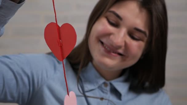 Joven chica atractiva hizo la preparación de decoraciones del corazón en un apartamento en el Día de San Valentín — Vídeo de stock