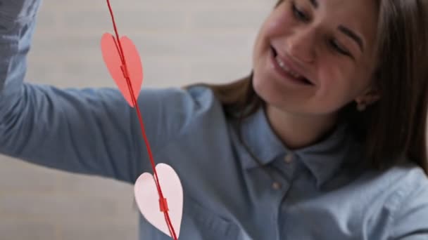 Mladý atraktivní dívka z přípravy srdce dekorace v bytě na Valentines Day — Stock video