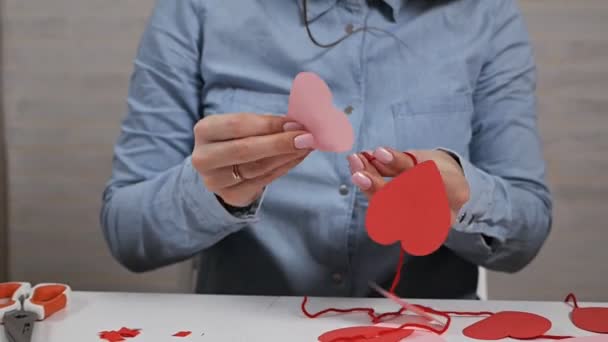 Creatividad, chica cortada de papel rojo con tijeras, corazones, flores, elementos para postales para amantes — Vídeo de stock