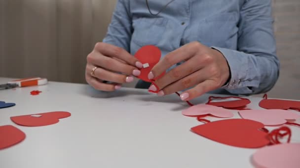 Creatividad, chica cortada de papel rojo con tijeras, corazones, flores, elementos para postales para amantes — Vídeo de stock