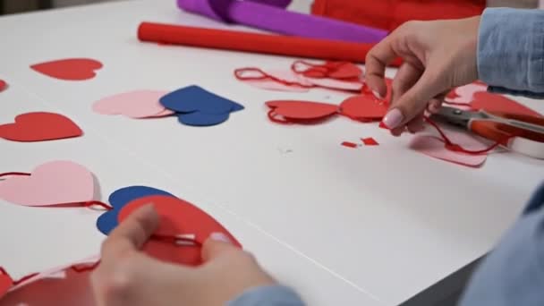 Kreativität, Mädchen aus rotem Papier ausgeschnitten mit Schere, Herzen, Blumen, Elementen für Postkarten für Verliebte — Stockvideo