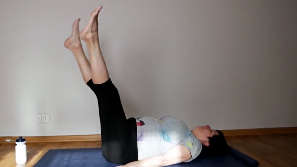 Mujer mayor saludable haciendo pilates o yoga, ejercicios de estiramiento — Vídeo de stock