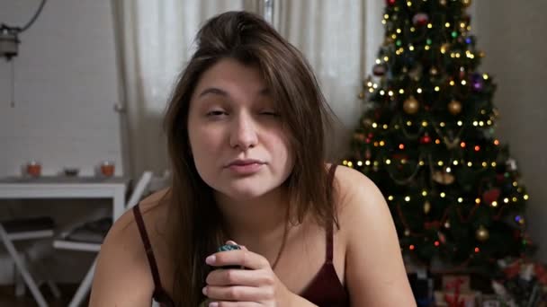 Une femme boit du whisky dans une bouteille au lit. Le concept de dépendance à l'alcool et de mauvaises habitudes n le matin après le réveillon du Nouvel An — Video