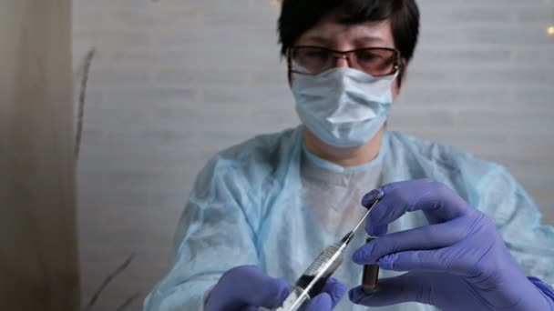 ワクチンへのコロナウイルスの反応をテストします。女性医師は、コロナウイルスに感染した血液で膜に薬を挿入します。新しい中国のウイルスの治療法の開発 — ストック動画