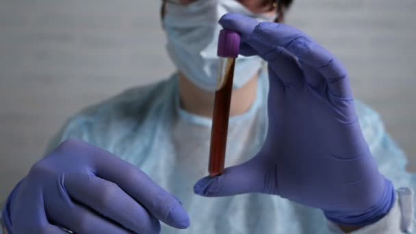 Doctora haciendo experimentos en un laboratorio sosteniendo un vaso de sangre — Vídeos de Stock