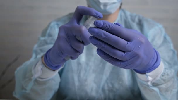 Een verpleegkundige in rubberen handschoenen spray een ontsmettingsmiddel op haar handen, close-up. Een verpleegkundige spuiten op hand desinfecterende oplossing. — Stockvideo