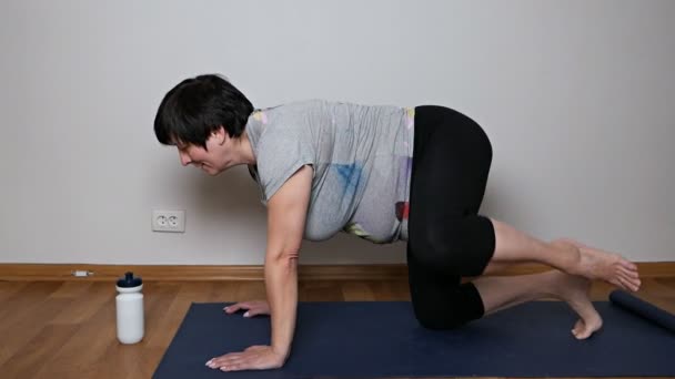 Sağlıklı yaşlı kadın pilates ya da yoga yapıyor, egzersiz yapıyor. — Stok video