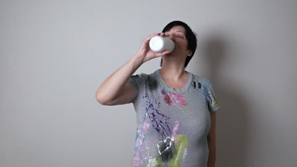 女性は、水のボトルを保持する年齢で、水を飲むと笑みを浮かべて。ワークアウト後に休憩を取るフィットネス女性 — ストック動画