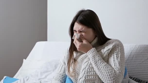 Gesundheitswesen und medizinisches Konzept. Junge kranke Frau niest nachts zu Hause auf der Couch. Mädchen laufende Nase und Haltungsgewebe, Grippesymptome — Stockvideo