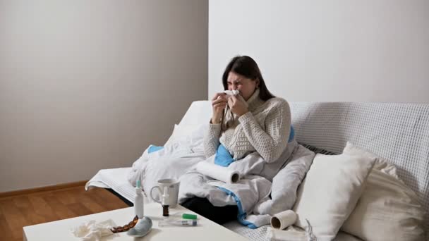 Gezondheidszorg en medisch concept.Jonge zieke vrouw niezen thuis 's nachts op de bank. Meisje loopneus en het houden van weefsel, griepsymptomen — Stockvideo