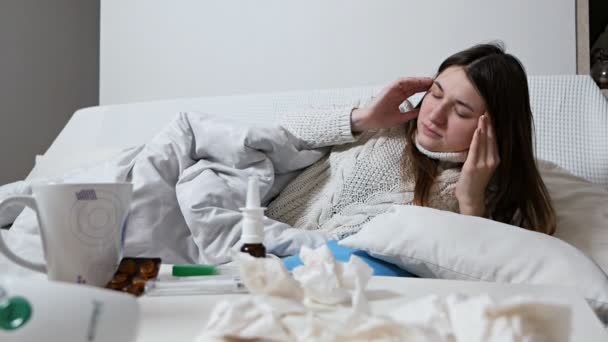 女人在床上病了。那位女士躺在床上吃药.生病的成年女孩。家庭医疗。流感和感冒是季节性的.卧房里生病的女人药物在床上。头痛 — 图库视频影像
