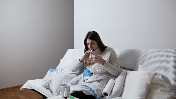 Focolaio di Coronavirus Spray per mal di gola. Foto di una donna che si cura la gola con uno spray e se lo spruzza in bocca. Concetto salute e malattia — Video Stock