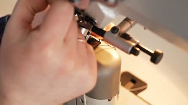 運動中のミシン針。ミシンの針を閉じるとすぐに上下に移動します。仕立て屋は縫製工場で革ベルトを縫う。革の縫製工程 — ストック動画
