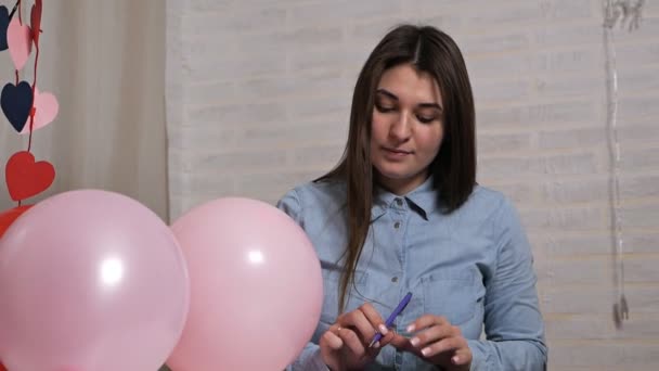 Egy fiatal lány ünnepet szervez. Főzés Valentin-napra, dekoráció, dekoráció, labdák — Stock videók