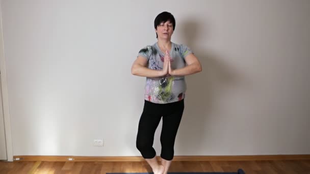 Active positive aged woman doing warm-up on in the living room — Stock Video