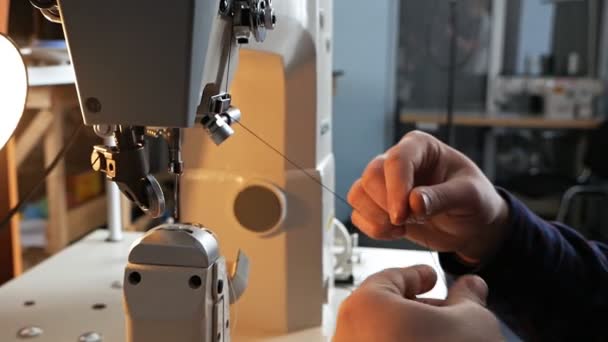 Un hombre instala una vieja máquina de coser para trabajar. Fábrica de costura . — Vídeos de Stock
