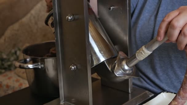 Человек готовит фаршированную колбасу из кишечника животных, наполняет ее начинкой из фарша — стоковое видео
