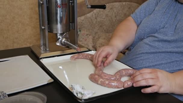 Um homem cozinha salsichas da maneira tradicional usando enchedor de salsichas. Salsichas de carne crua close-up. Produção de iguarias de carne em casa — Vídeo de Stock