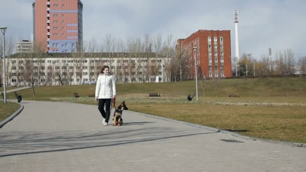 Glückliche junge Frau, die mit ihrem Schäferhund auf der Straße spazieren geht. Deutsche Welpen.Zeitlupe — Stockvideo