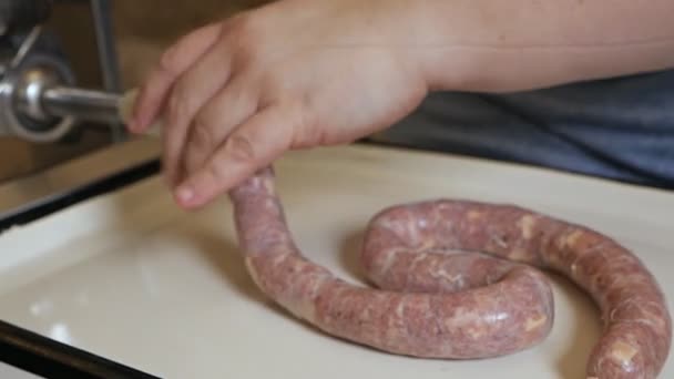 A man cooks sausages in the traditional way using sausage filler. Raw beef sausages close-up. Production of meat delicacies at home — Stock Video