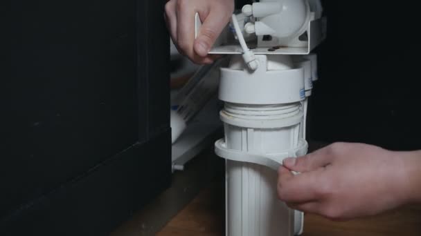 Loodgieter of Man hand te vervangen cartridges voor waterfilter in huis keuken. Reiniging van het vaste watersysteem. Een man zet een waterfilter. waterfilter — Stockvideo