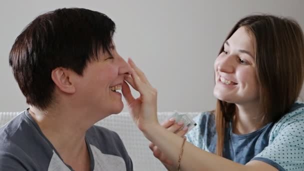 Elderly mother talking with an adult daughter, sharing news, gossip and caring for her face — Stock Video