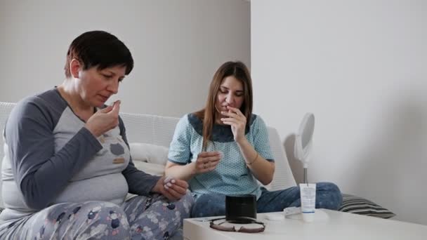 Starsza matka rozmawia z dorosłą córką w domu, spędza czas razem badając nowe kosmetyki — Wideo stockowe