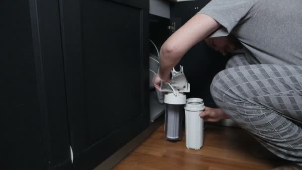 Huiswaterfiltratiesysteem. Het concept van schoon water. Een omgekeerd osmose waterzuiveringssysteem thuis. Het installeren van waterfilters onder de gootsteen in de kast — Stockvideo