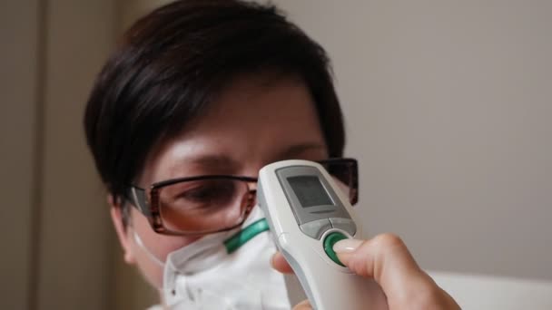 Koronovirüs enfeksiyonu şüphesi olan bir hastada temas olmayan sıcaklık ölçümü. Sıcaklık normal. — Stok video
