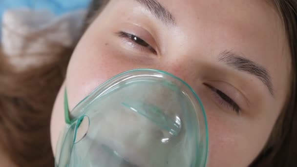 Женщина в кислородной маске лежит в постели, проблемы со здоровьем, депрессия, болезнь страха — стоковое видео