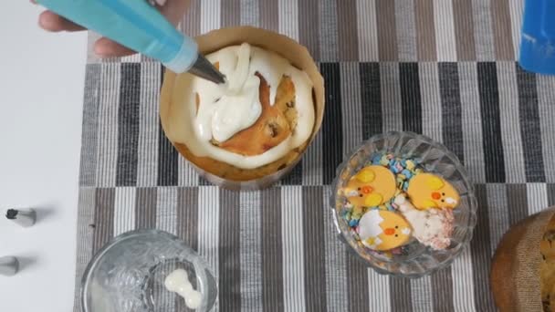 白いクリーム、ケーキの上のクリーム、お菓子の注射器とイースターケーキを置く女性 — ストック動画