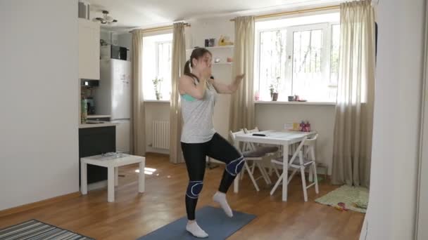 Belle femme mince faisant des exercices cardio matinaux, en vêtements de sport dans une salle moderne — Video