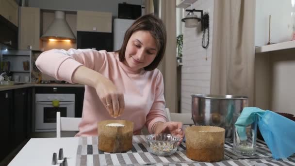 A girl decorates a holiday cake. Easter cake with colored glaze. Festive, religious cake. Cupcake for Easter. Baking for dessert. Close-up shot — Stock Video