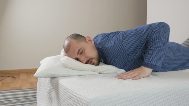 Retrato de un hombre obeso con dificultad para hacer ejercicios en la cama. Hombre perezoso y deporte — Vídeo de stock