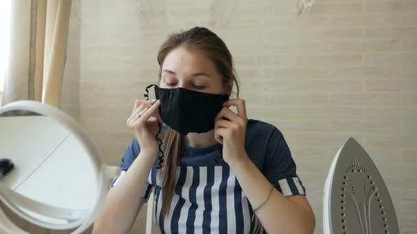 Covid 19 Женщина выбирает маску перед зеркалом — стоковое видео