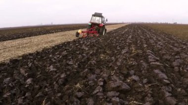 Bulutlu sonbahar gününde tarlayı traktör. Havadan görüntüleri.