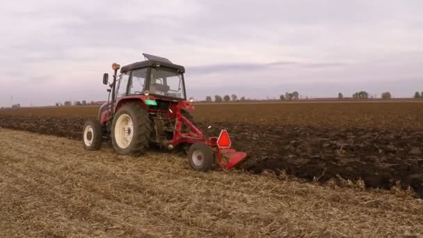 曇った秋の日のフィールドを耕すトラクターです 空中映像 — ストック動画