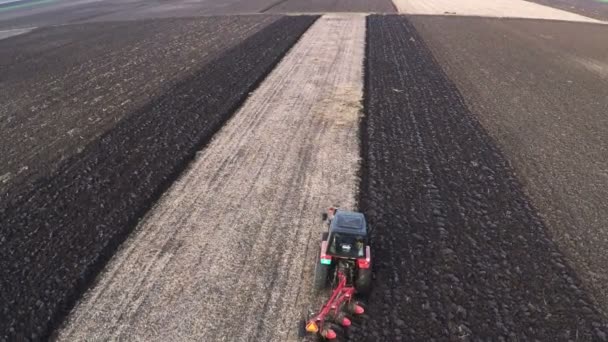 曇った秋の日のフィールドを耕すトラクターです 空中映像 — ストック動画