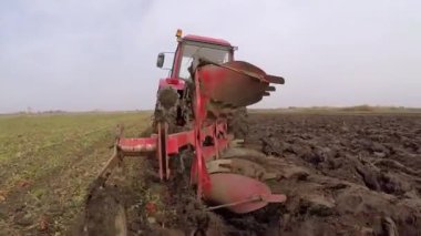 Arkadan görünüşü yeşil sahada arazi ekimi sırasında sürüş kırmızı traktör