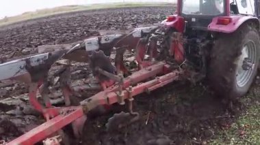 Kırmızı Traktör yeşil sahada arazi ekimi sırasında sürüş