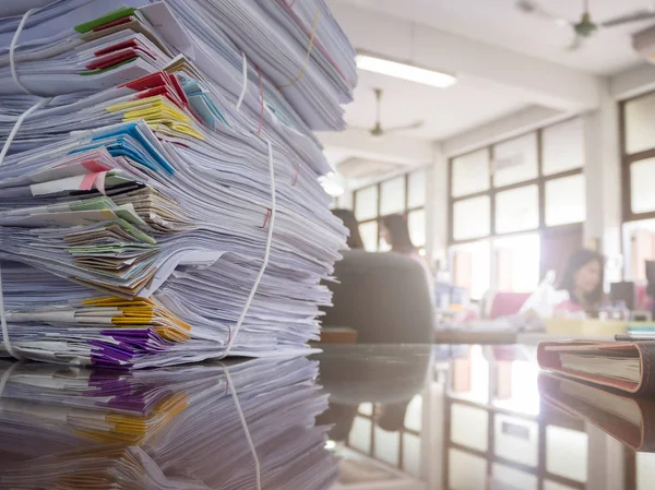 Montón de documentos sin terminar en el escritorio de la oficina con fondo de mujer de negocios — Foto de Stock